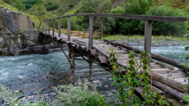 istock Old wooden bridge over a river Argun in Upper Khevsureti, Georgia 1270990908