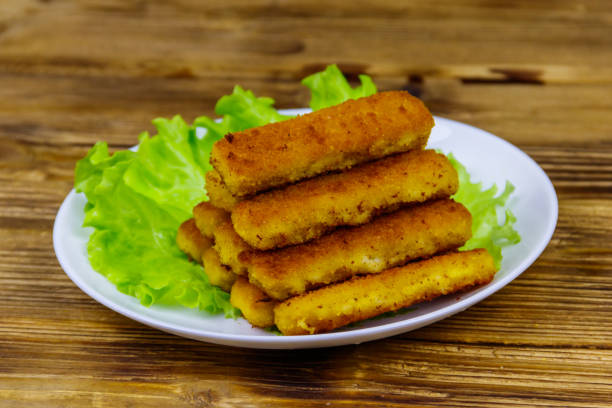 istock Fried fish fingers on a plate with lettuce on wooden table 1270991104
