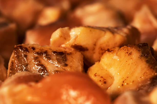 Closeup view of salmon are fried in a pan.