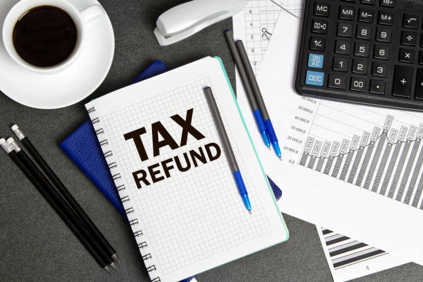istock Notebook with a notes TAX REFUND on the businessman's Desk 1271001406