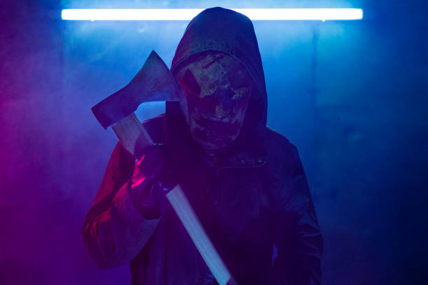 uomo sciarpa che indossa una maschera, con in mano un'ascia. - horror monster spooky movie foto e immagini stock