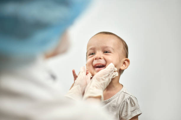 Well baby exam Pediatrician checking baby teeth. Dentist examines teeth of baby boy middle eastern ethnicity photos stock pictures, royalty-free photos & images