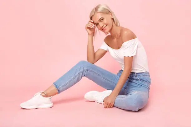 Photo of Young adult woman in denim wear clothes looking at camera with smile