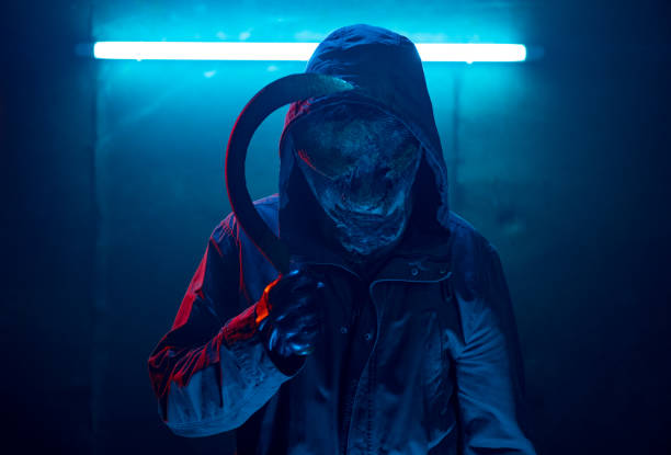 istock Scary man with a sickle standing in front of blue neon light. 1271004107