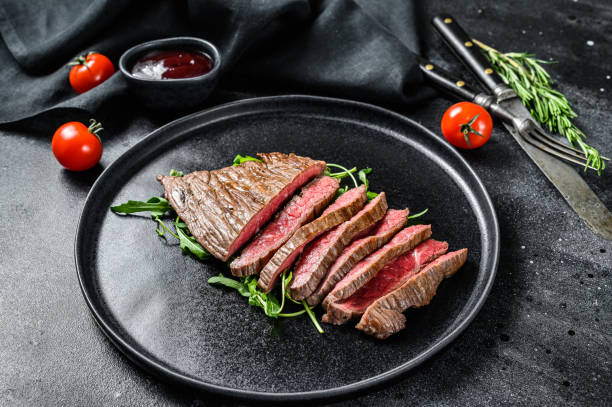 플랫 아이언 스테이크를 구워 서 잘라. 대리석 쇠고기 고기. 검은 색 배경. 위쪽 보기 - steak close up grilled skirt steak 뉴스 사진 이미지