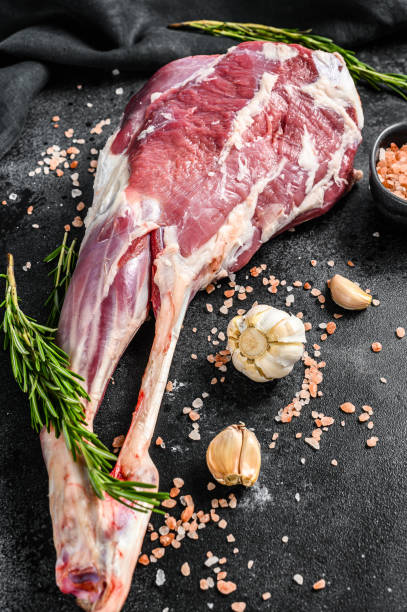 istock Whole lamb leg. Raw organic meat. Black background. Top view 1271010563