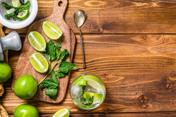 istock Drink making tools and ingredients for cocktail, lemonade, mojito. Lime, ice and mint. Wooden background. Top view. Copy space 1271010608