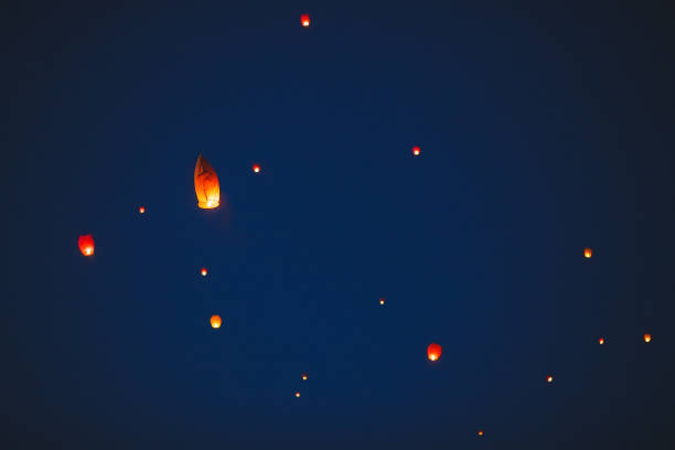 istock Flying lantern in the dark sky at night 1271012532