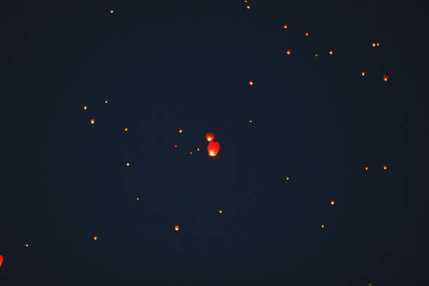 istock Flying lantern in the dark sky at night 1271012555