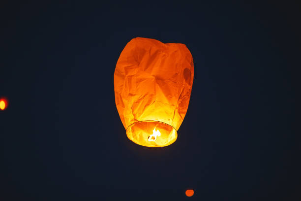istock Flying lantern in the dark sky at night 1271012581