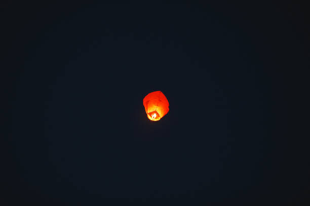 istock Flying lantern in the dark sky at night 1271012591