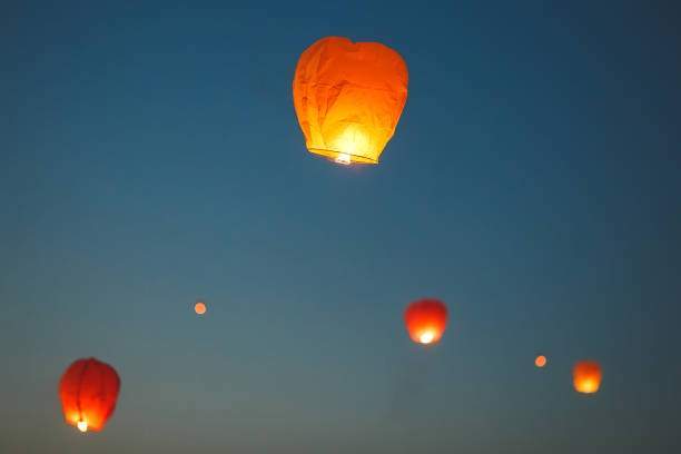istock Flying lantern in the dark sky at night 1271012636