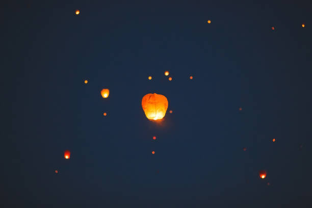 istock Flying lantern in the dark sky at night 1271012639
