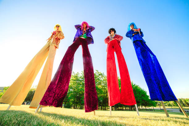 Young people on stilts posing against the blue sky