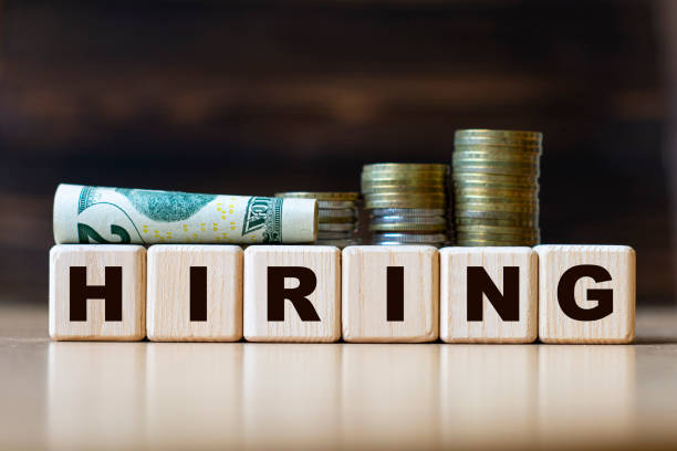 istock HIRING word on diced on a beautiful dark background with coins 1271013680