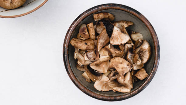 Fresh raw chopped mushrooms close up in a bowl directly from above, copy space Fresh raw chopped mushrooms close up in a bowl, flat lay with copy space crimini mushroom stock pictures, royalty-free photos & images
