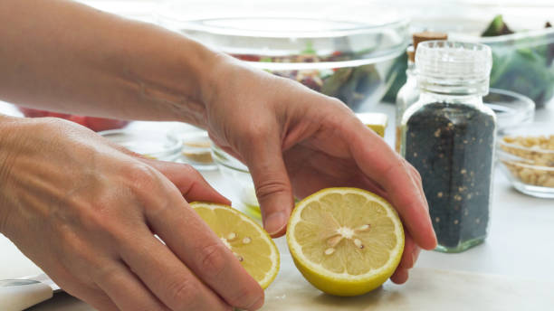 istock Chef cuts lemon in half. Salad dressing recipe, ingredient close up on kitchen table 1271013949