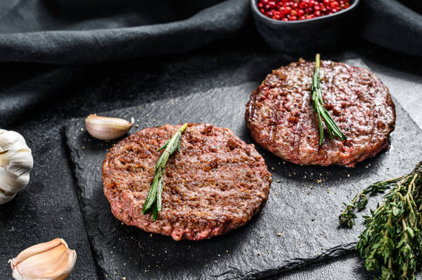 istock Grilled ground beef patties. BBQ meat. Black background. Top view 1271014745
