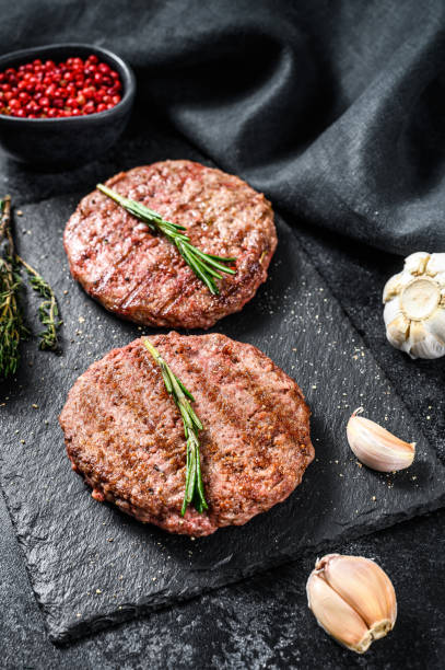 istock Grilled Beef burger patties. Meat cutlet. Black background. Top view 1271014763