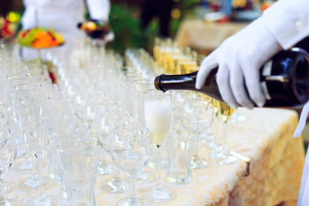 istock Bartender in white gloves pouring champagne into glasses. 1271018099