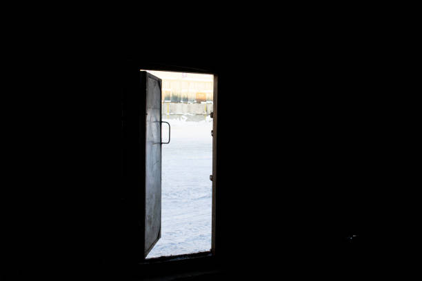 view from dark warehouse through open door on  snow. Frozen day