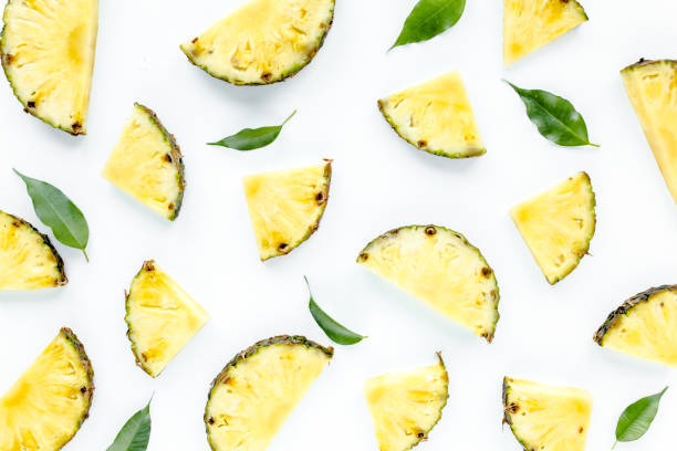 istock Slices pineapple with green leaves isolated on white background. Flat lay, top view 1271020673