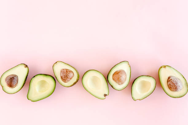 istock Avocado on pink background. Tropical abstract background with avocado. Food concept. flat lay, top view 1271020732