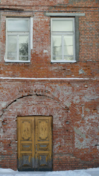 istock close-up vitage Wooden doors in brick wall and window above 1271021067