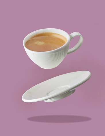 levitating coffee cup on purple background