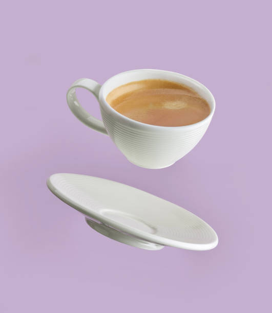 kaffeetasse auf lila hintergrund - levitation stock-fotos und bilder