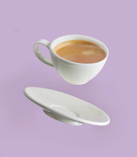 taza de café sobre fondo púrpura - levitación fotografías e imágenes de stock