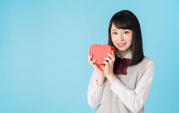 istock Asian school girl holding a heart shape box. 1271040671