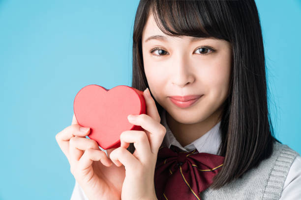 istock Asian school girl holding a heart shape box. 1271040701