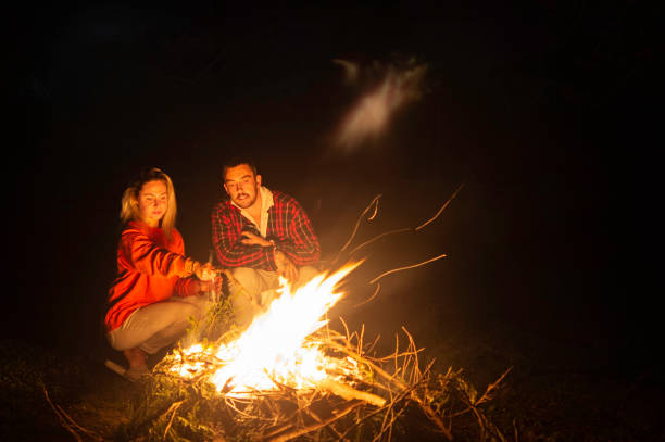 istock Young romantic couple enjoying campfire late evening 1271044553
