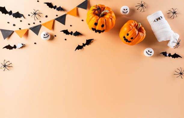istock Halloween decorations made from pumpkin, paper bats and black spider on pastel orange background. Flat lay, top view with copy space for text. 1271045200