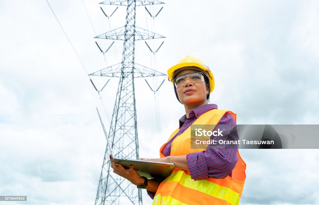 Electrical engineer women use laptop working Electrical engineer women use laptop working and checking the power grids. Women Stock Photo