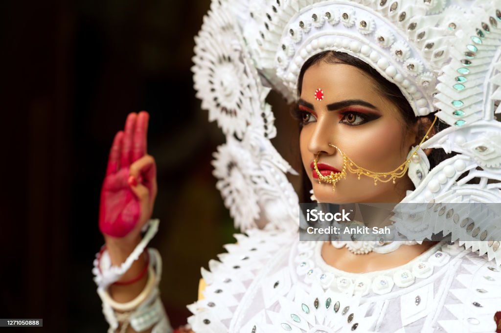 Beautiful Indian Woman dressed as Hindu Goddess. Beautiful Indian Woman dressed as Hindu Goddess Durga, looking away from camera. This is a representative concept of Agomoni or Home coming of of Goddess Durga. Durga Stock Photo