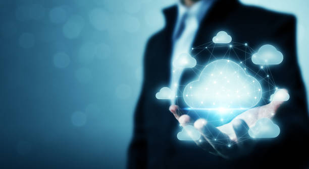 A businessman in a suit holds out his hand, displaying a glowing, digital cloud symbol surrounded by interconnected lines and smaller cloud icons against a blurred blue background.