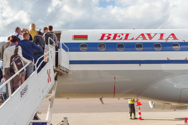 belarusian airline belavia plane parked at airport while passengers enter by stairway - entering airplane imagens e fotografias de stock