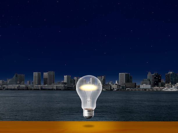 the light bulb glowing in mid-air over the shelf against tokyo bay area. - city night lighting equipment mid air imagens e fotografias de stock