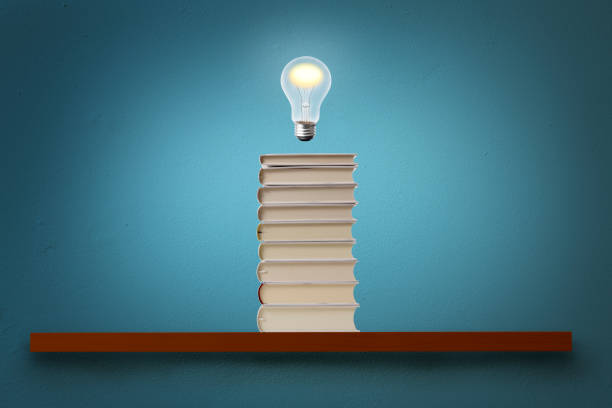 istock The light bulb glowing in mid-air over the blank book on a shelf. 1271070851