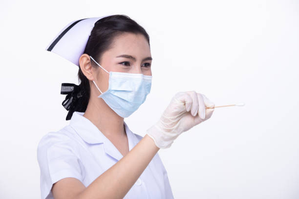 Portrait of serious female nurse standing arms crossed isolated over white background. Vertical shot.
