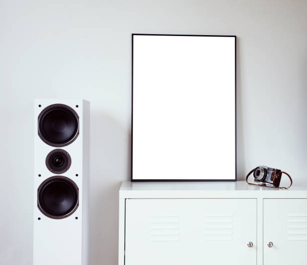 istock Poster Frame Mockup in white modern interior. Modern audio stereo system with white speakers on bureau in modern interior. 1271078288