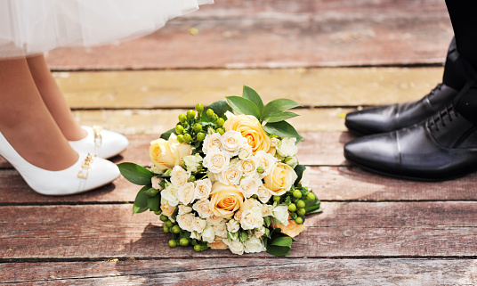 Wedding bouquet on a wooden background.Flowering branch with white delicate flowers on wooden surface. Declaration of love, spring. Wedding card, Valentines Day greeting. Wedding rings. Wedding bouquet, background. Empty wooden tabletop