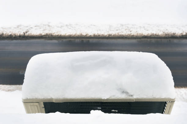 klimaanlage bedeckt mit schnee hängen an der wand des hauses - air conditioner window heat hot day stock-fotos und bilder