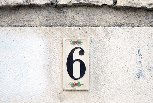 House number six.Number six on the wall, detail of a number of information in a house in the city