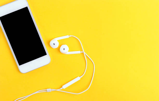 istock smartphone and earphone business concept yellow background 1271079865