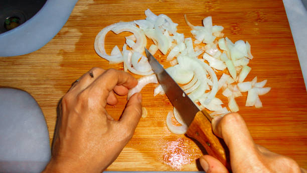 istock Sliced organic white onion pieces on the wooden chopping board 1271084607