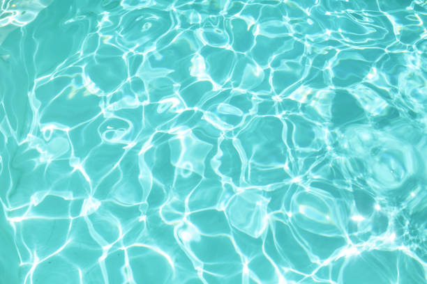 Water In Pool Texture. Turquoise Pure Aqua Surface With Ripples And Glares Pattern. Fresh Liquid With Sunlight Reflection In Summer.