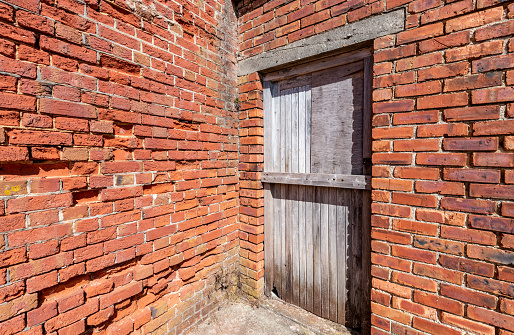 Old Door in Eroded Red Brick Wall